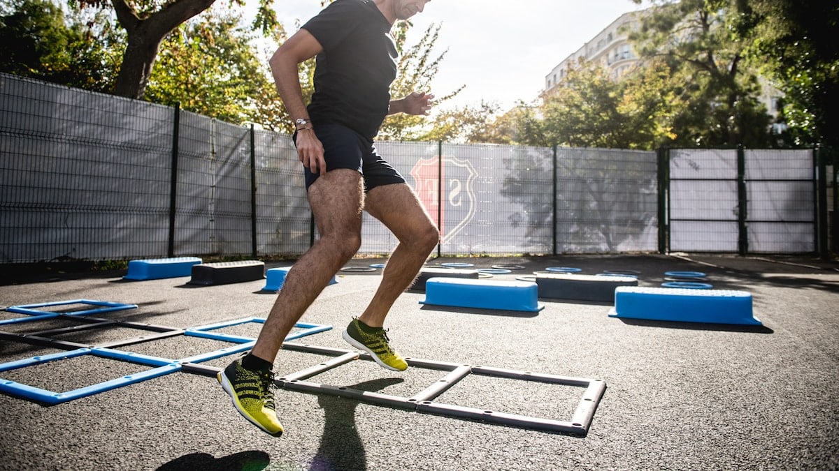 man in gray t-shirt and black shorts running on yellow and black skateboard during daytime